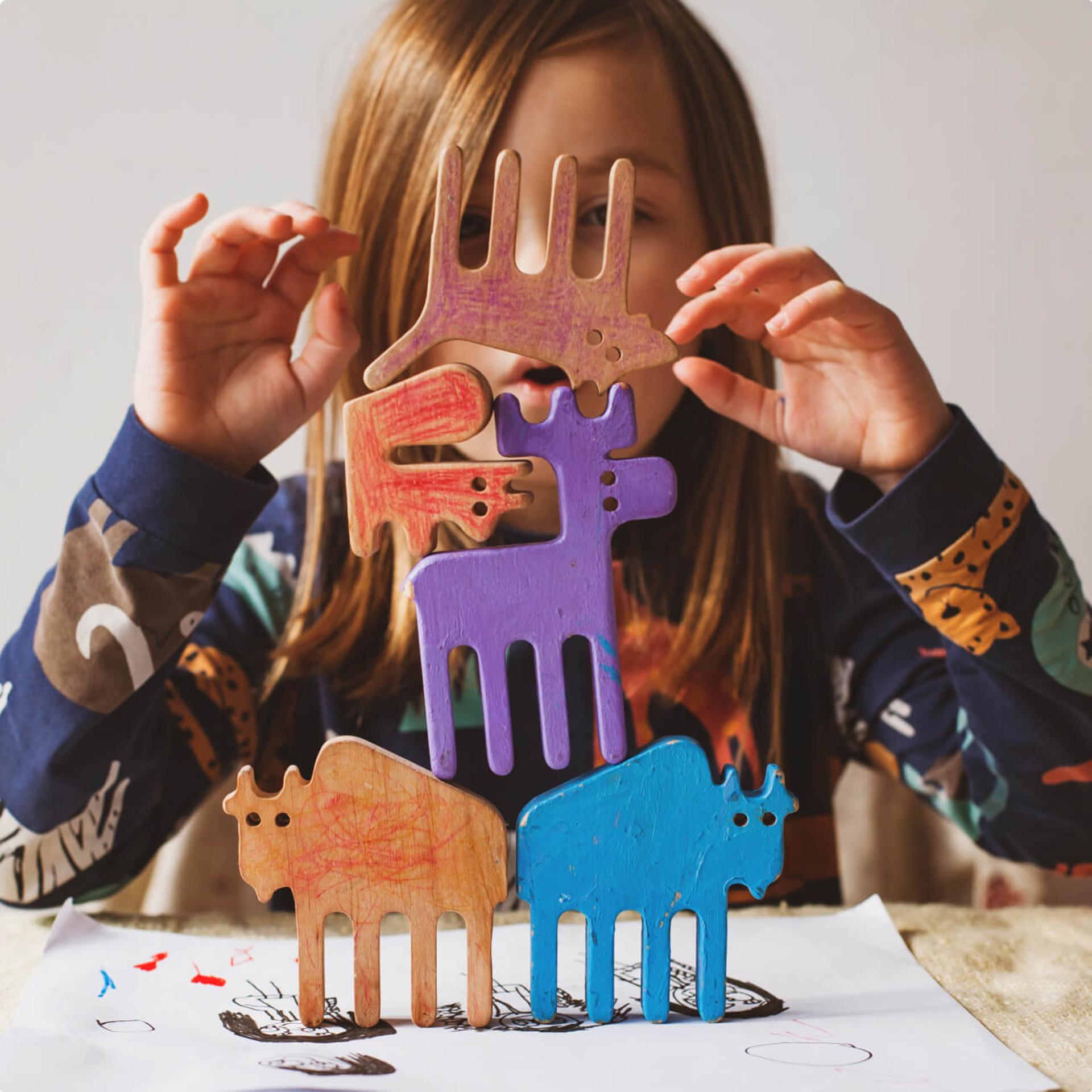 A girl stacking animal toys.